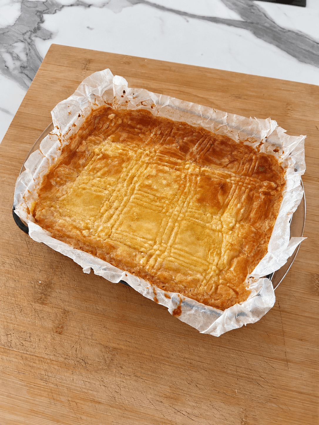 Boterkoek in bakpapier op een houten plank
